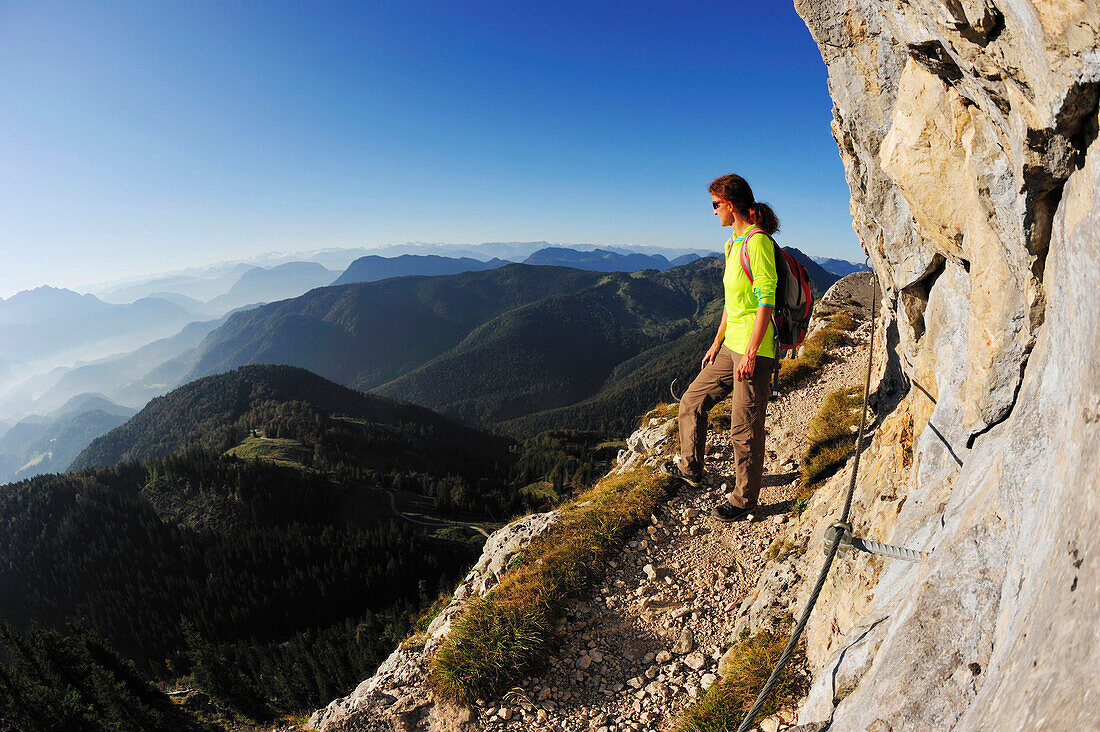 Woman walking on an exposed trail at a rockface, Brunnstein, Bavarian Prealps, Upper Bavaria, Bavaria, Germany
