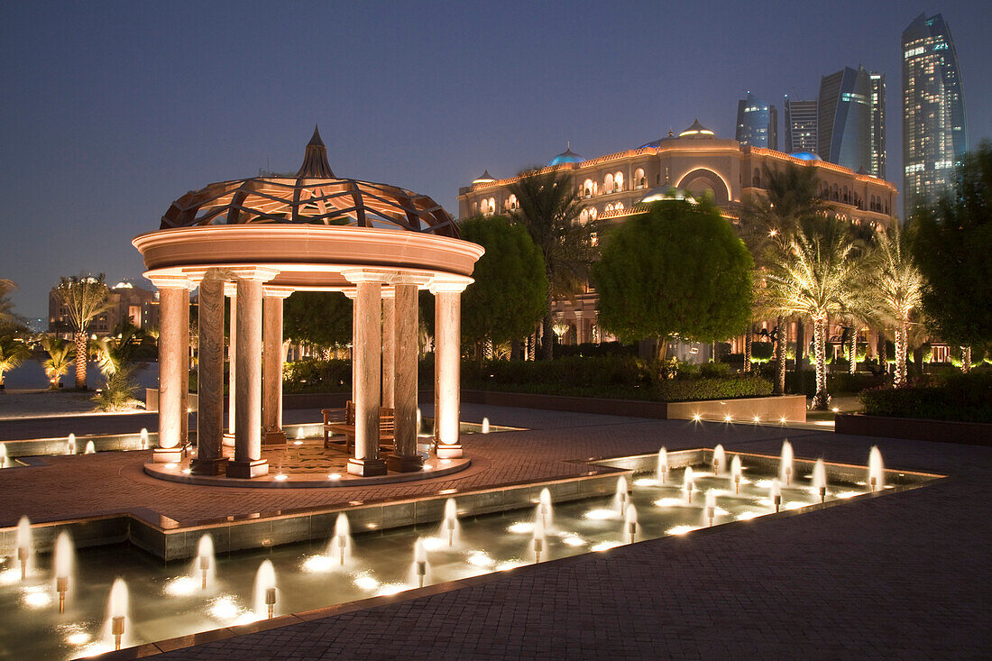 Ein Pavillion und Springbrunnen vor dem Emirates Palace Hotel in der Abenddämmerung, Abu Dhabi, Vereinigte Arabische Emirate