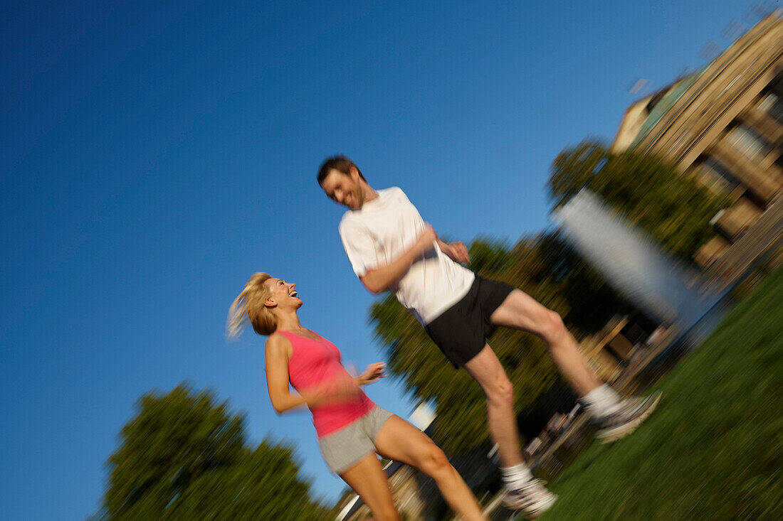 Young couple jogging, Upper Castle Garden, Staatstheater, Stuttgart, Baden Wurttemberg, Germany