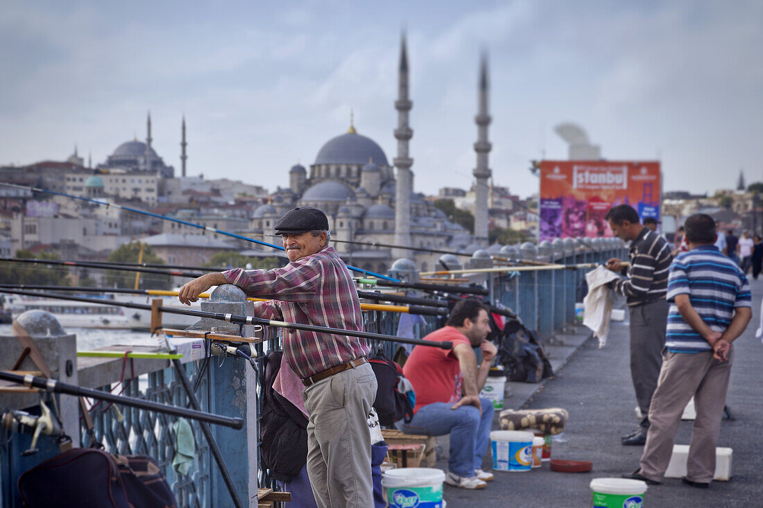 Anglers on Galata bridge at Golden Horn, Blue mosque in the background, Istanbul, Turkey, Europe