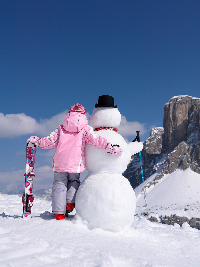 Little girl with skis an snowman, Alto Adige, South Tyrol, Italy, Europe