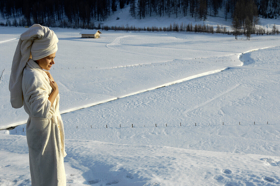 Frau im Bademantel vor verschneiter Landschaft, Alto Adige, Südtirol, Italien, Europa