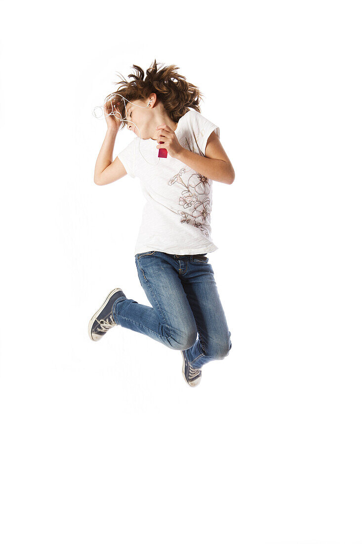 Girl jumping, listening to MP3 player