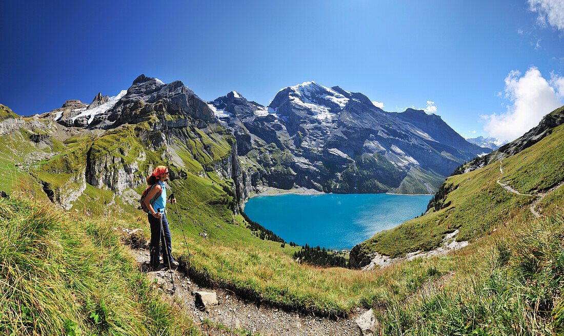 Frau blickt über Oeschinensee auf Gebirgslandschaft, Blüemlisalp, UNESCO Weltnaturerbe Schweizer Alpen Jungfrau-Aletsch, Berner Oberland, Kanton Bern, Schweiz