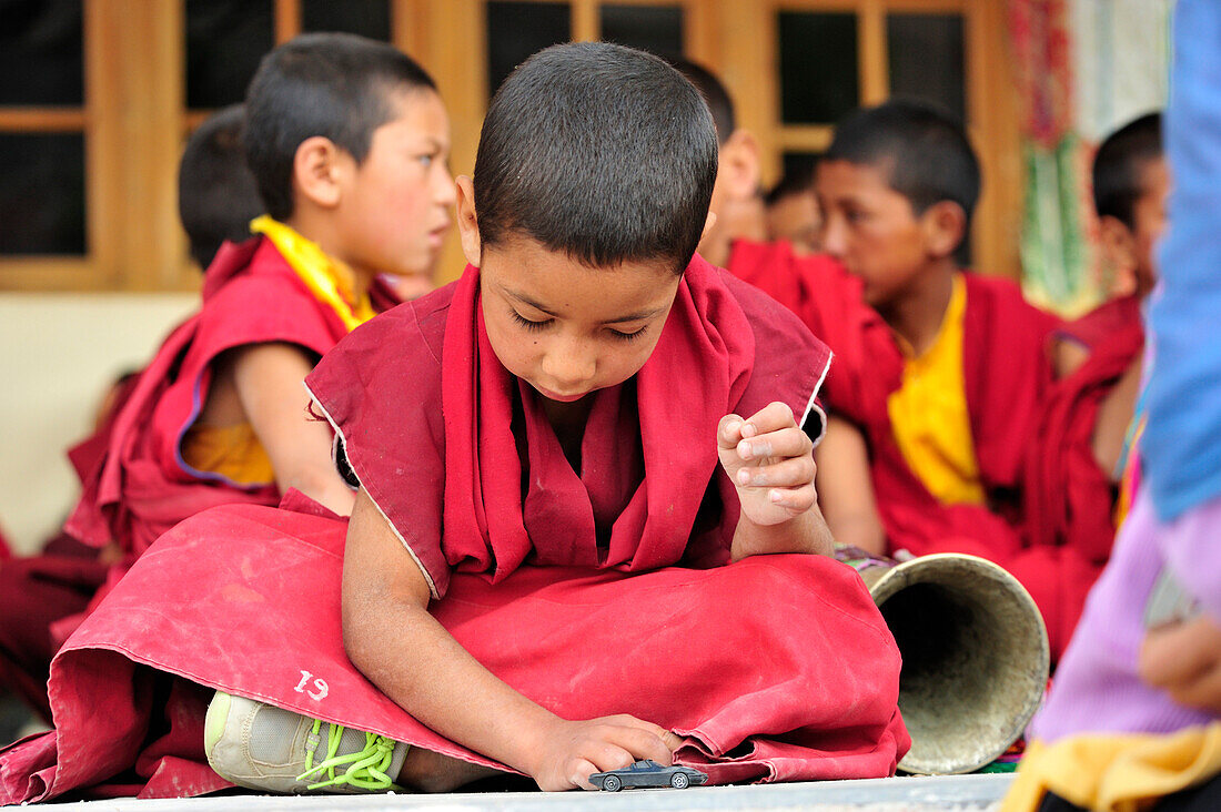 Novize spielt mit Spielzeugauto, Klosterfest, Phyang, Leh, Industal, Ladakh, Jammu und Kashmir, Indien