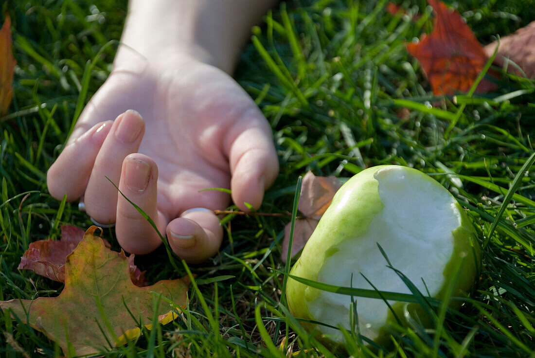 Hand and Half-Eaten Green Apple