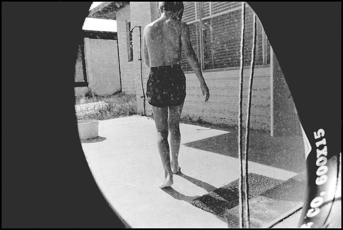 Young Boy in Swimsuit Viewed Through Inner Tube, Rear View, Gulf Shores, Alabama, USA