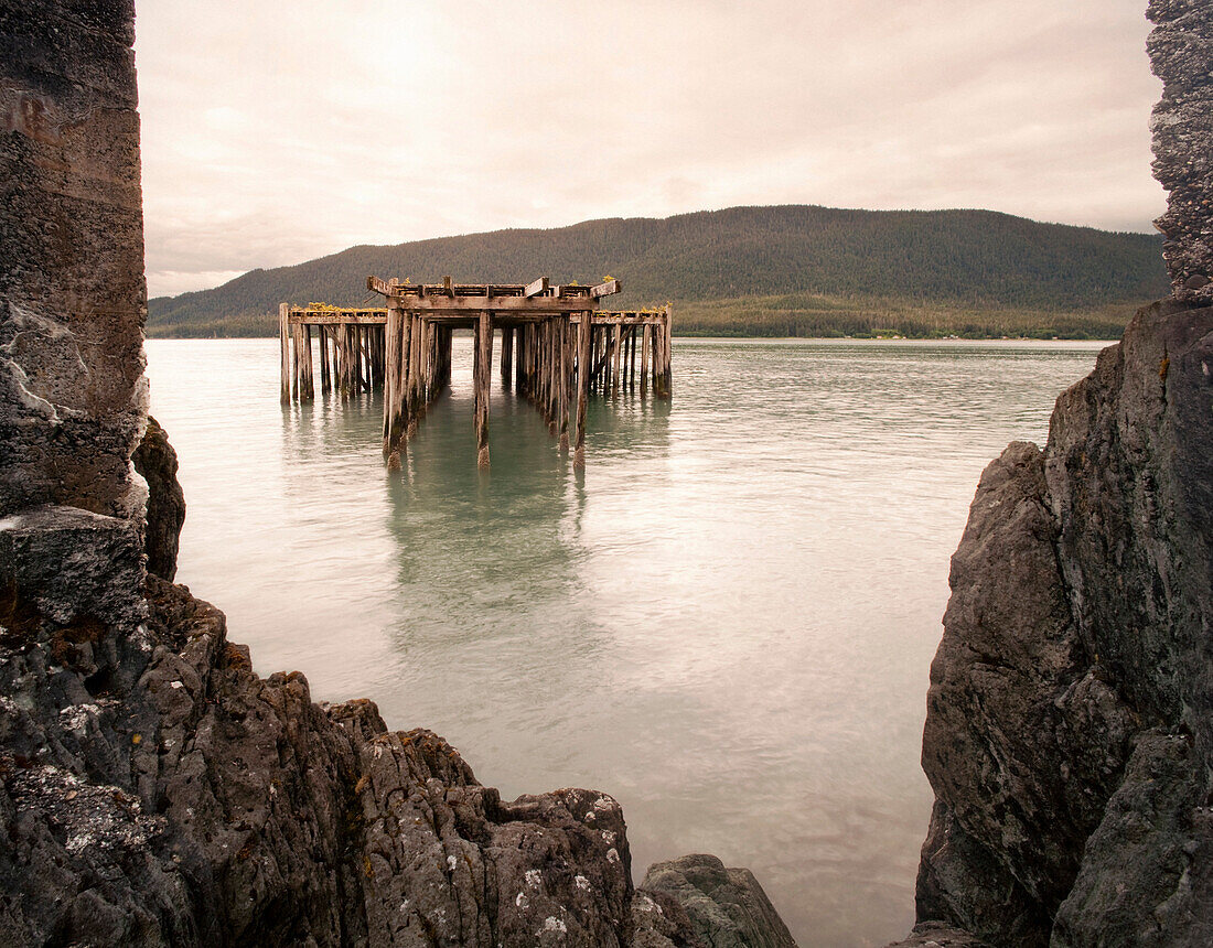 Old Fishing Pier Viewed Though Sea Wall Opening, Juneau, Alaska, USA