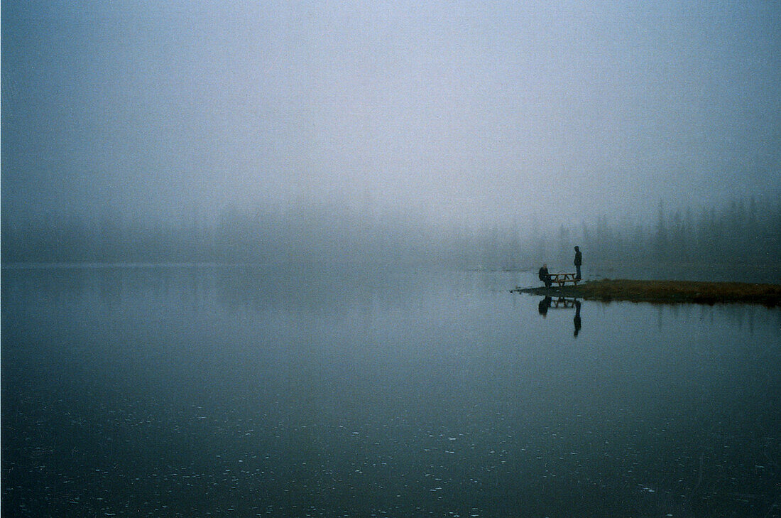 Two People at Edge of Misty Lake