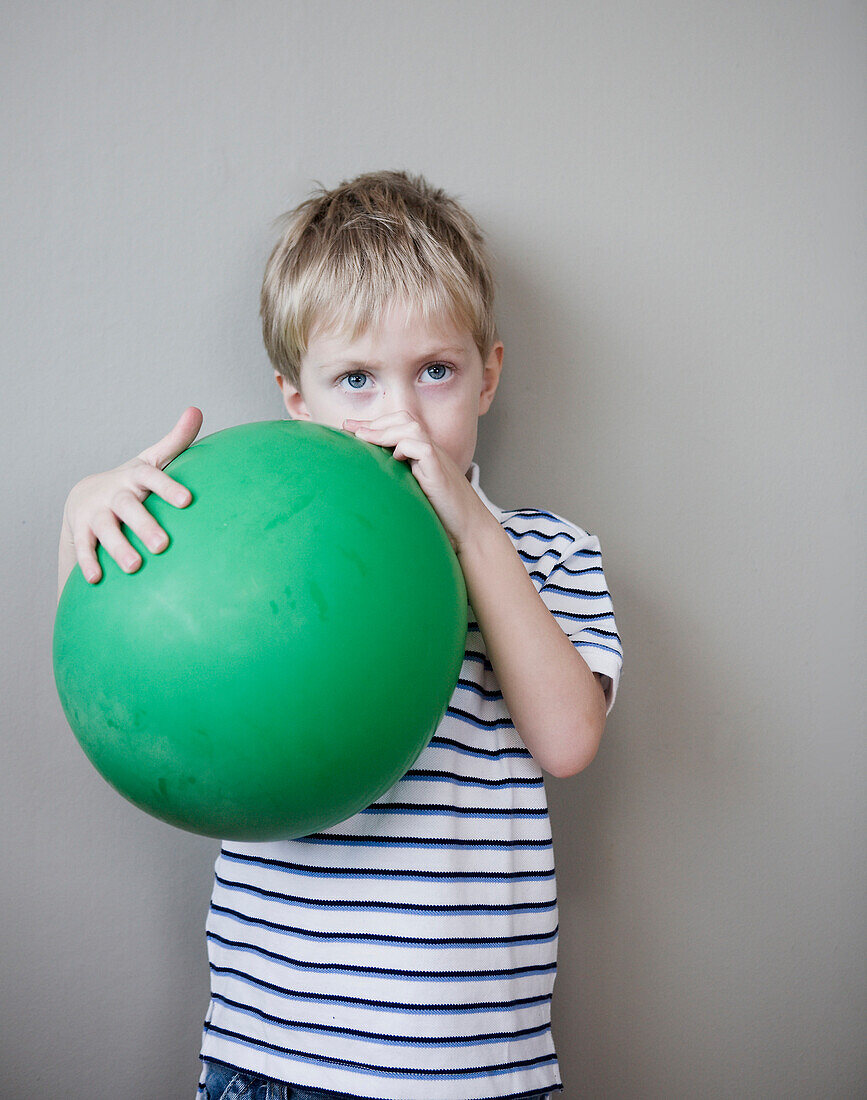 Young Boy Holding Green Balloon