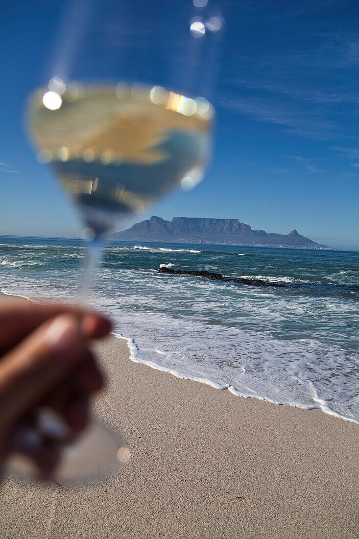 Strandimpression mit Weinglas am Bloubergstrand mit Blick auf den Tafelberg und Kapstadt, Westkap, Südafrika, RSA, Afrika