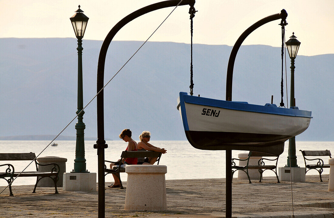 Zwei Frauen auf einer Bank am Hafen von Senj am Velebit, Adriaküste, Kroatien