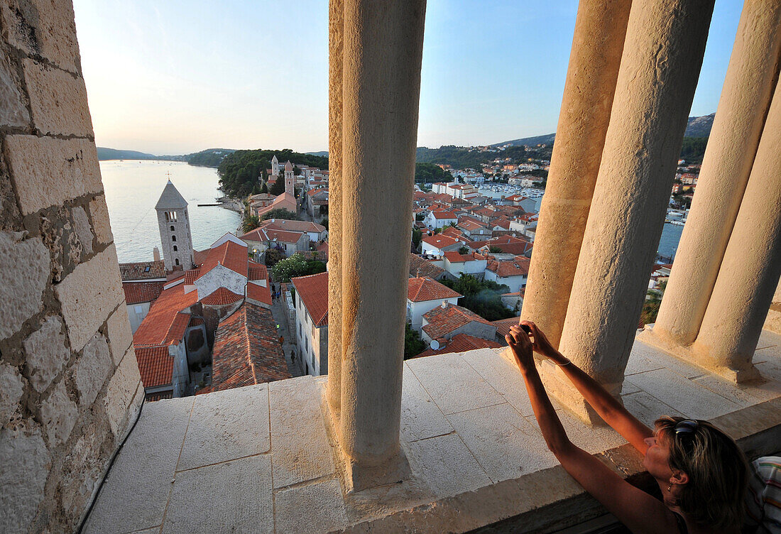 Woman taking a photograph, view from the tower of St. Andriji over the town of Rab, Rab Island, Kvarnen Gulf, Croatia