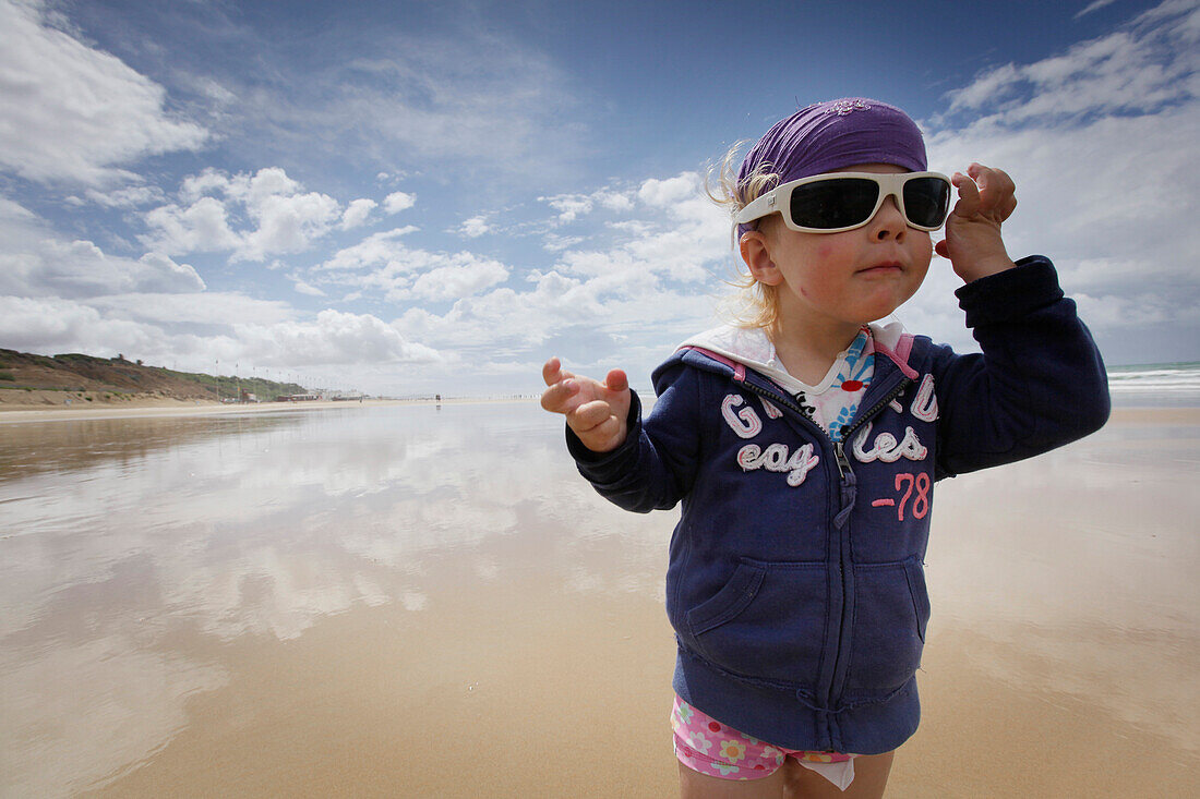 Kleines Mädchen mit Sonnenbrille am Strand, Conil de la Frontera, Costa de la Luz, Andalusien, Spanien