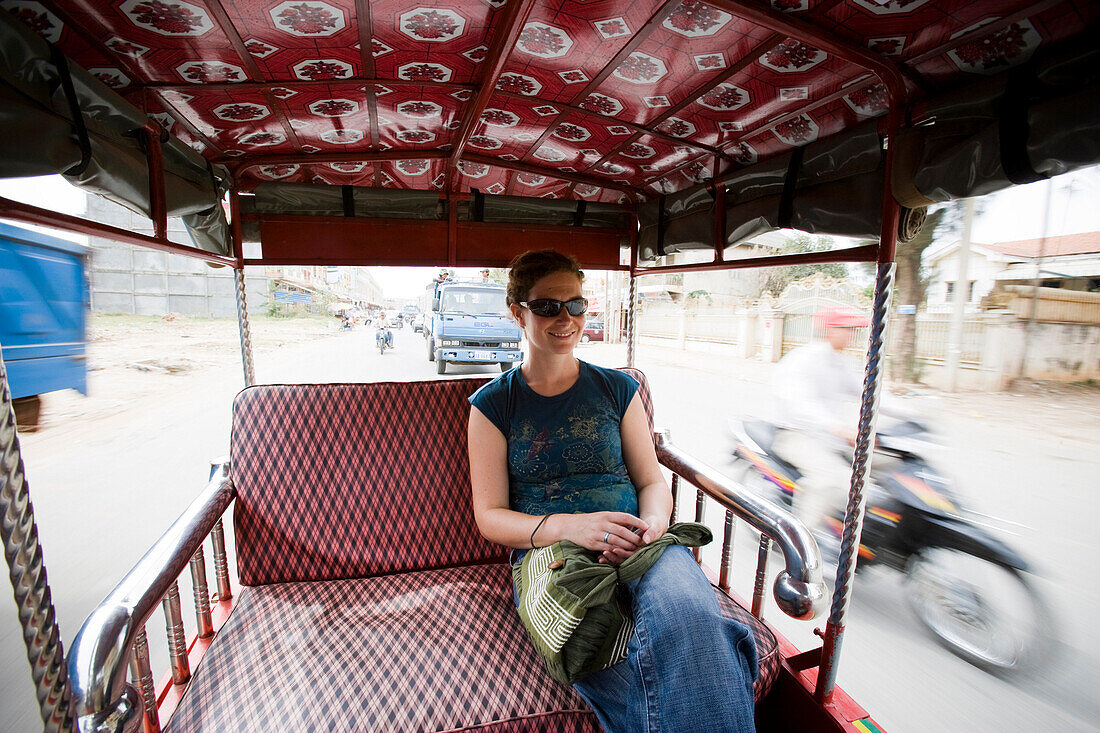 Young woman riding in tuk-tuk in Phnom Penh, Cambodia, Phnom Penh, Cambodia.