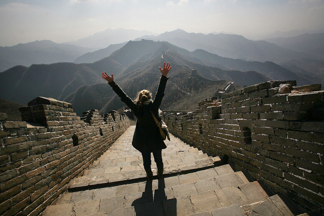 Tourist cheering on Great Wall of China, China