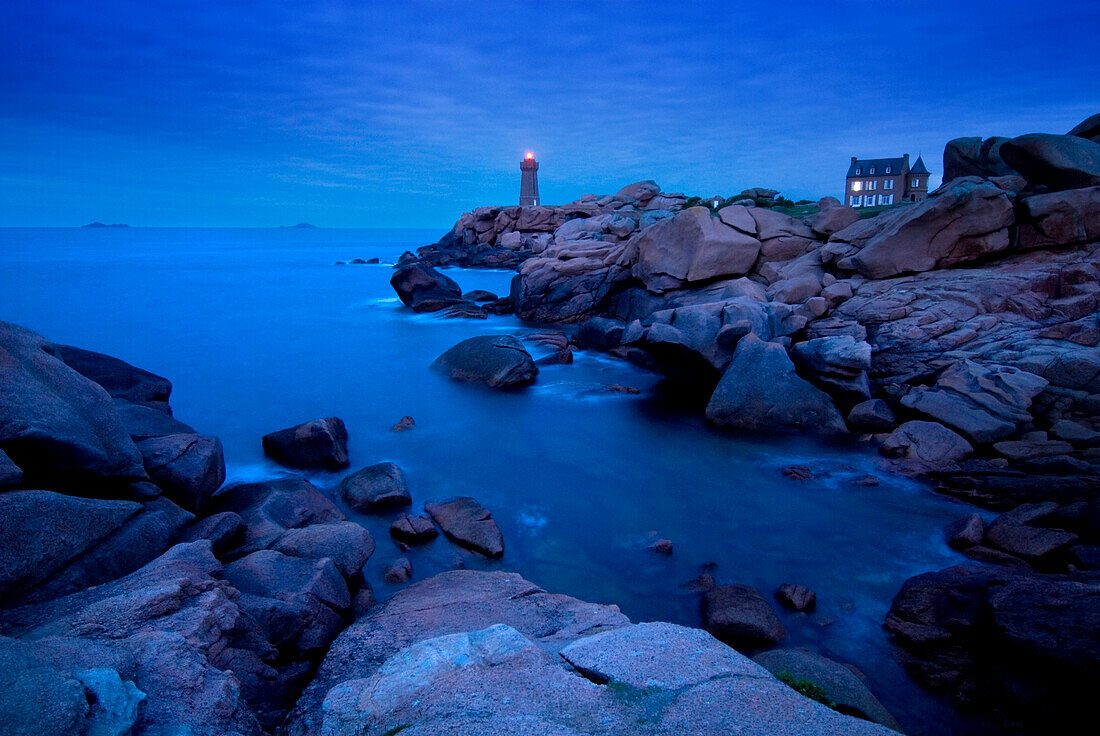 Small lighthouse and house at dusk, Cote de Granit Rose, Ploumanach, Brittany, France