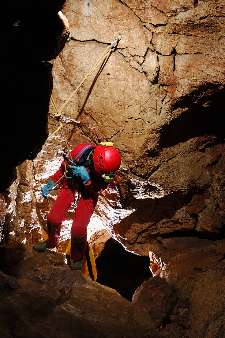 Speleology, caving, caver at the top of a pit, Aven de la Potence, Hérault (France)