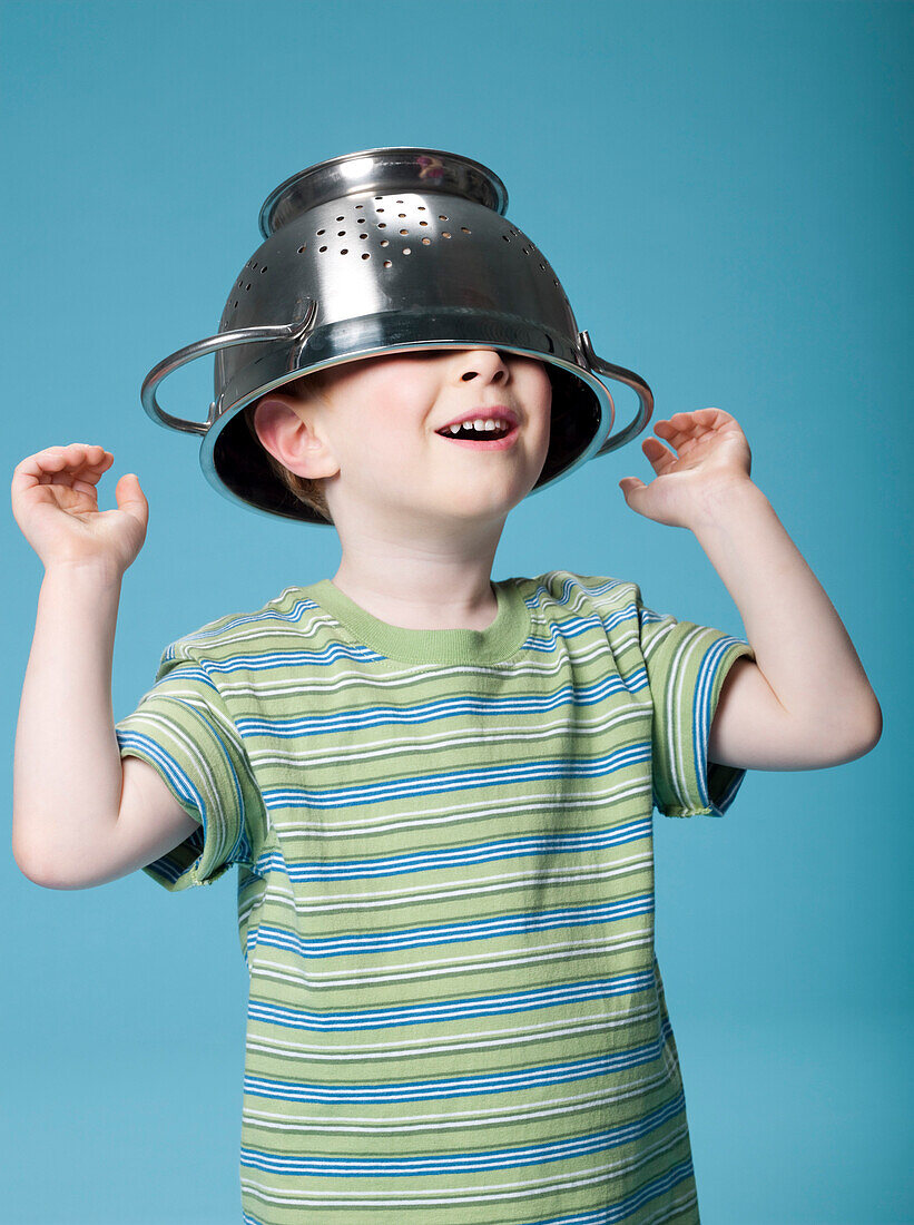 Little boy playing with a colander