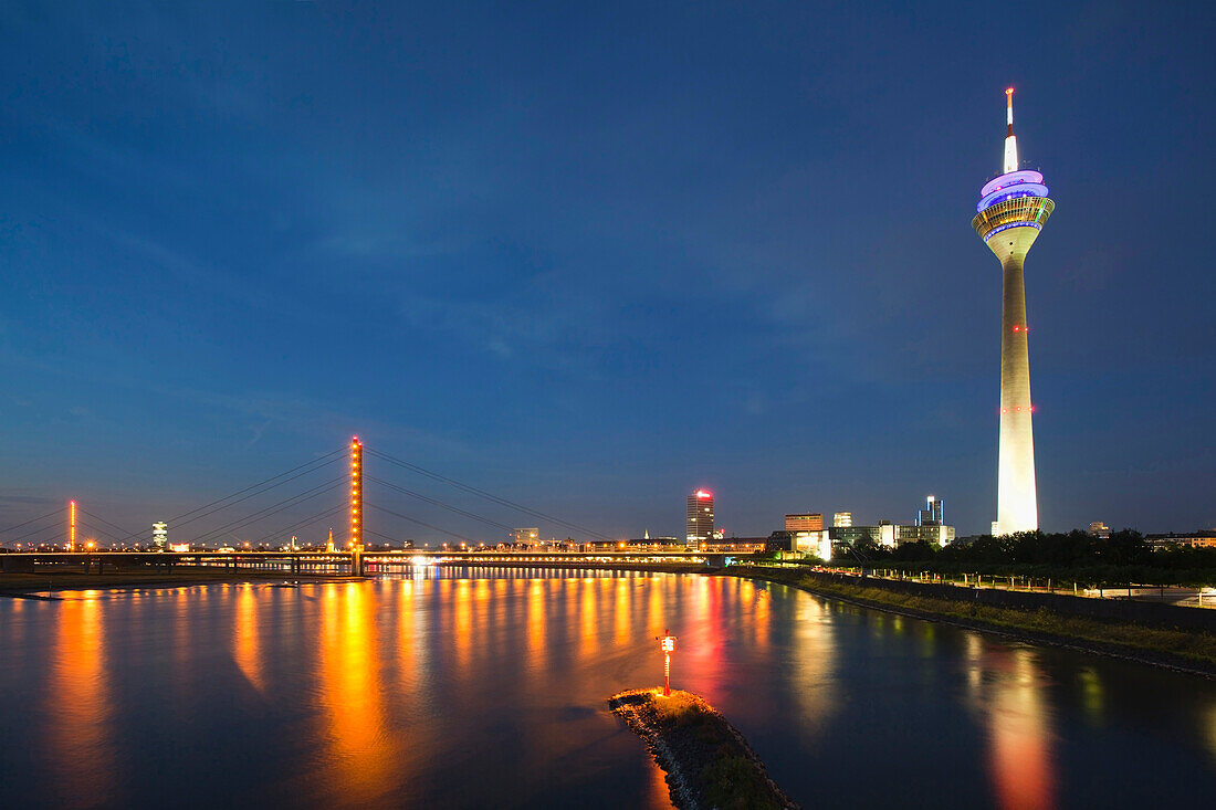 View over the Rhine river to Duesseldorf skyline with Rheinkniebrücke and Rheinturm tower at night, Duesseldorf, Rhine river, North Rhine-Westphalia, Germany, Europe