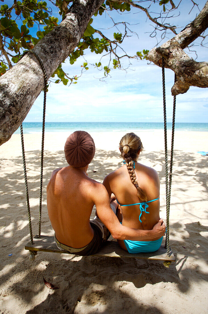 Tourists sitting on swing at Red Frog Beach, Bocas del Toro, Caribbean, Panama