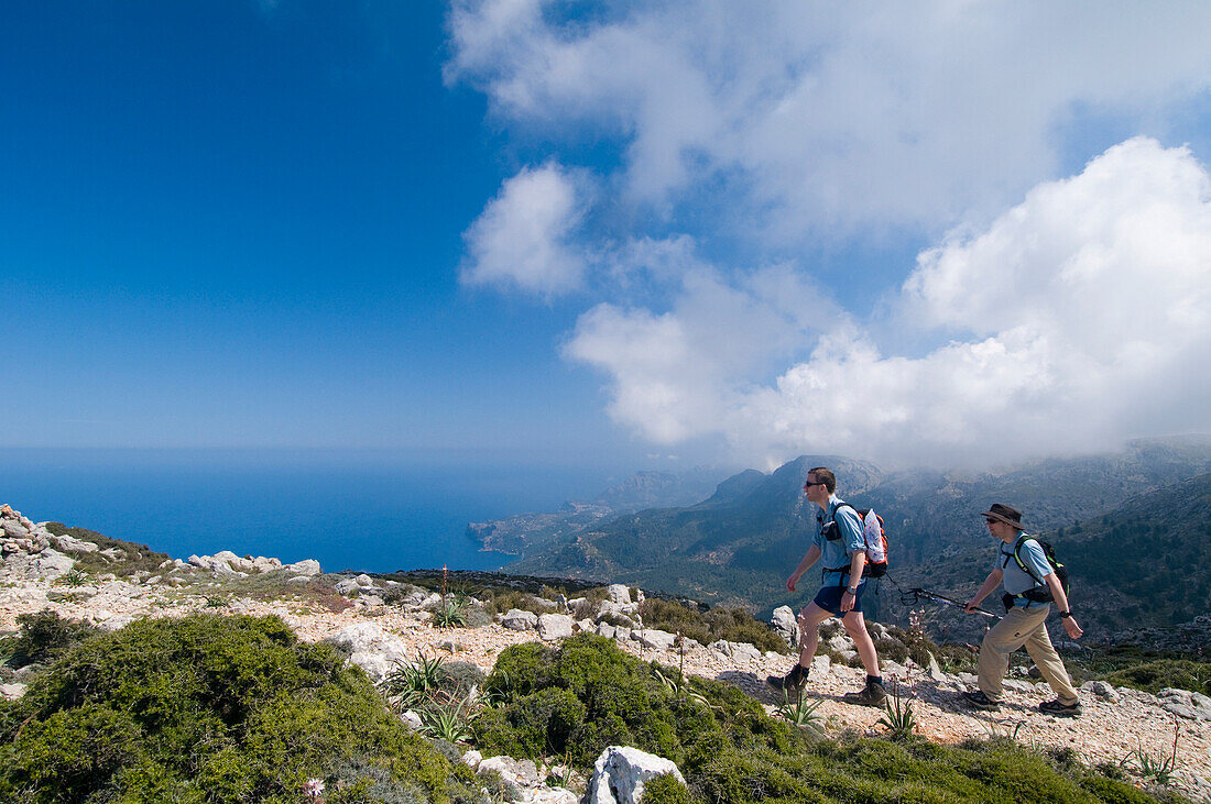 Two hikers on track towards Teix peak, side view, Majorca, Ballearic Islands, Spain, track built by Archduke Ludwig Salvador