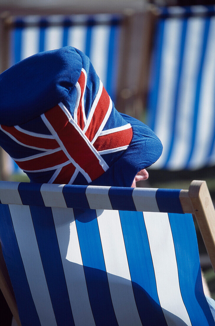 Man in Union Jack hat in sunchair, Skegness, Linconshire, England, UK  
