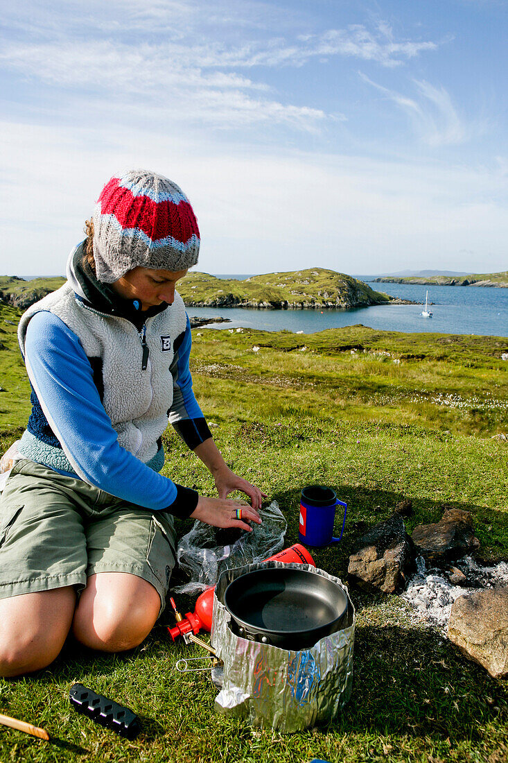 Young woman preparing picnic, Outer Hebrides, Scotland