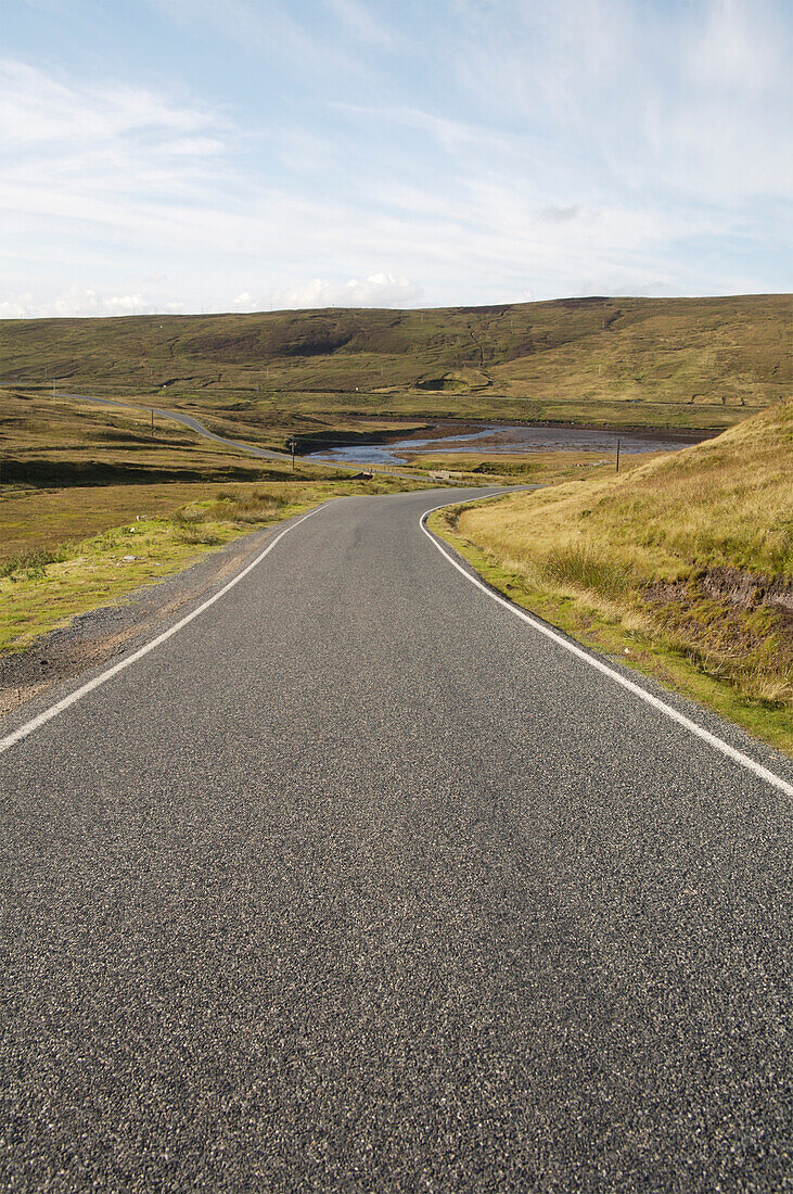 Empty single lane road through hills, Yell, Shetland Islands
