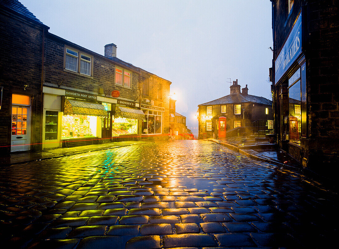 Haworth main street illuminated at dusk, West Yorkshire, England