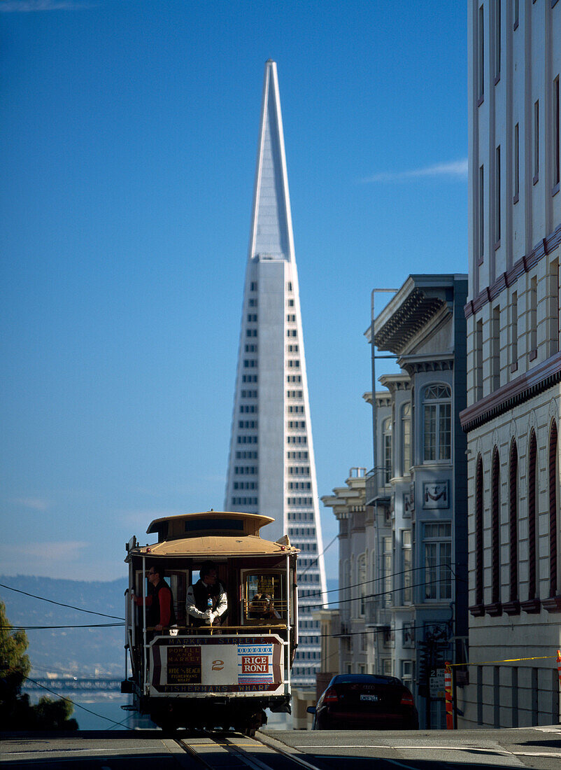 Cable car going down Washington Street on Nob Hill with the Trans-America Pyramid behind, San Francisco, California