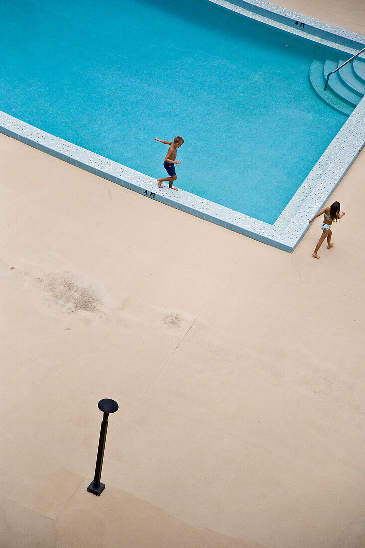 Children (10-11) walking around swimming pool, elevated view, Jupiter, Florida, USA