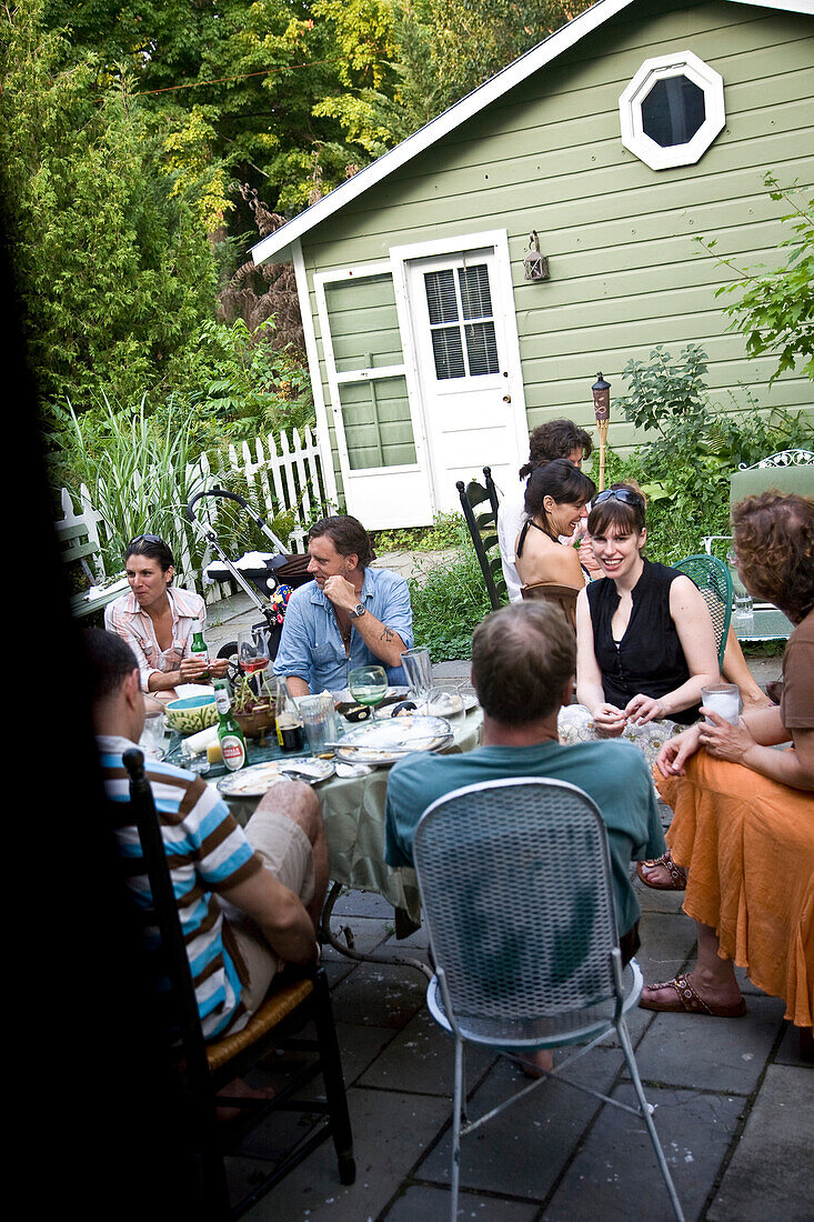 People eating dinner in back yard, Hudson Valley, New York State, USA
