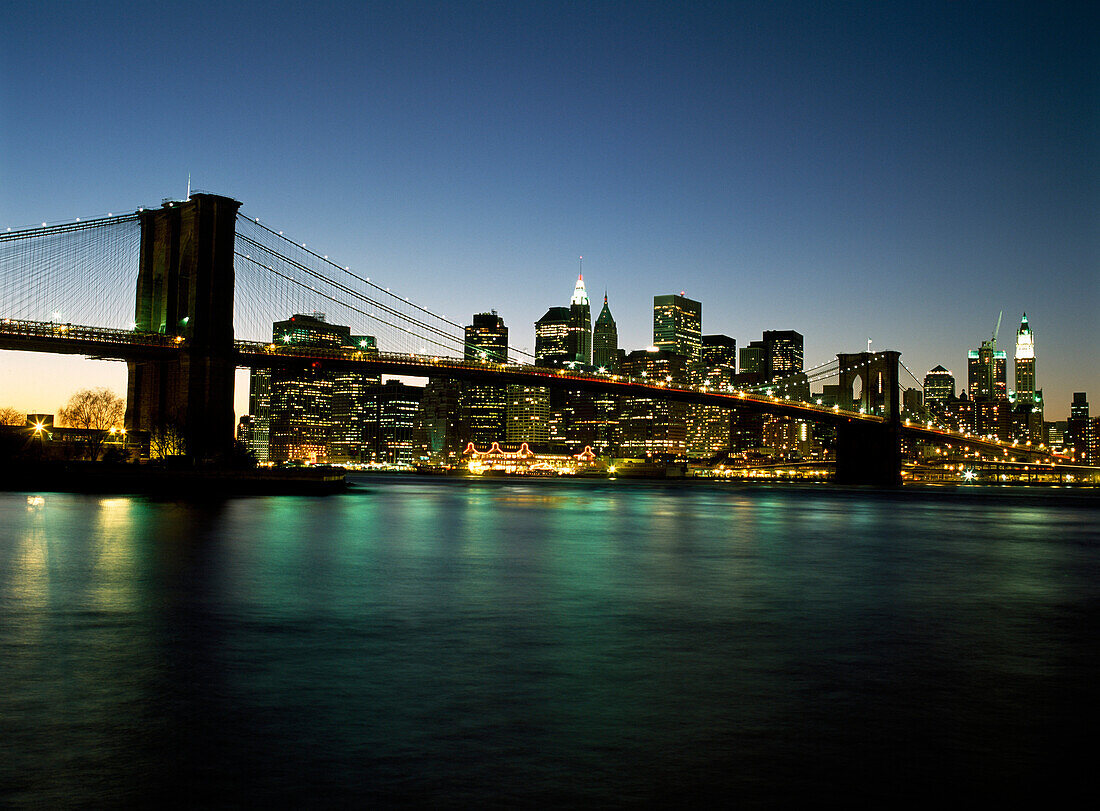 Looking across the East River and the Brooklyn Bridge to the Financial District at dusk, New York, USA