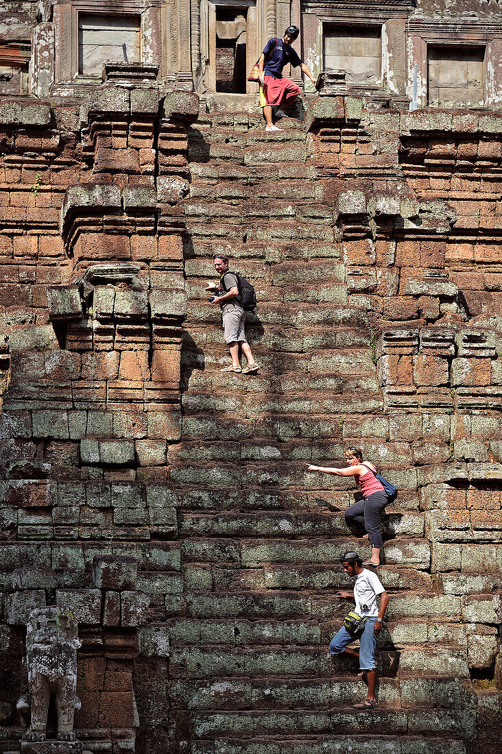 Tourists climb ancient temples of Angkor, former Khymer kingdom, UNESCO world heritage, Siem Reap, Cambodia