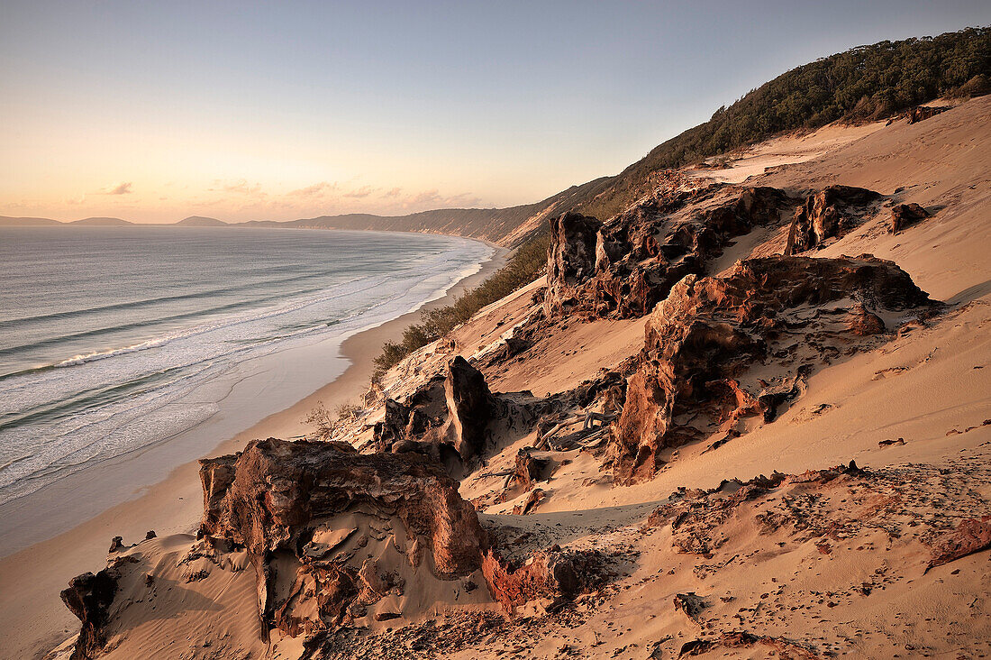 Sanddüne und Felsen am Rainbow Beach während Sonnenaufgang, UNESCO Weltnaturerbe, Fraser Island,  Süd Pazifik, Queensland, Australien