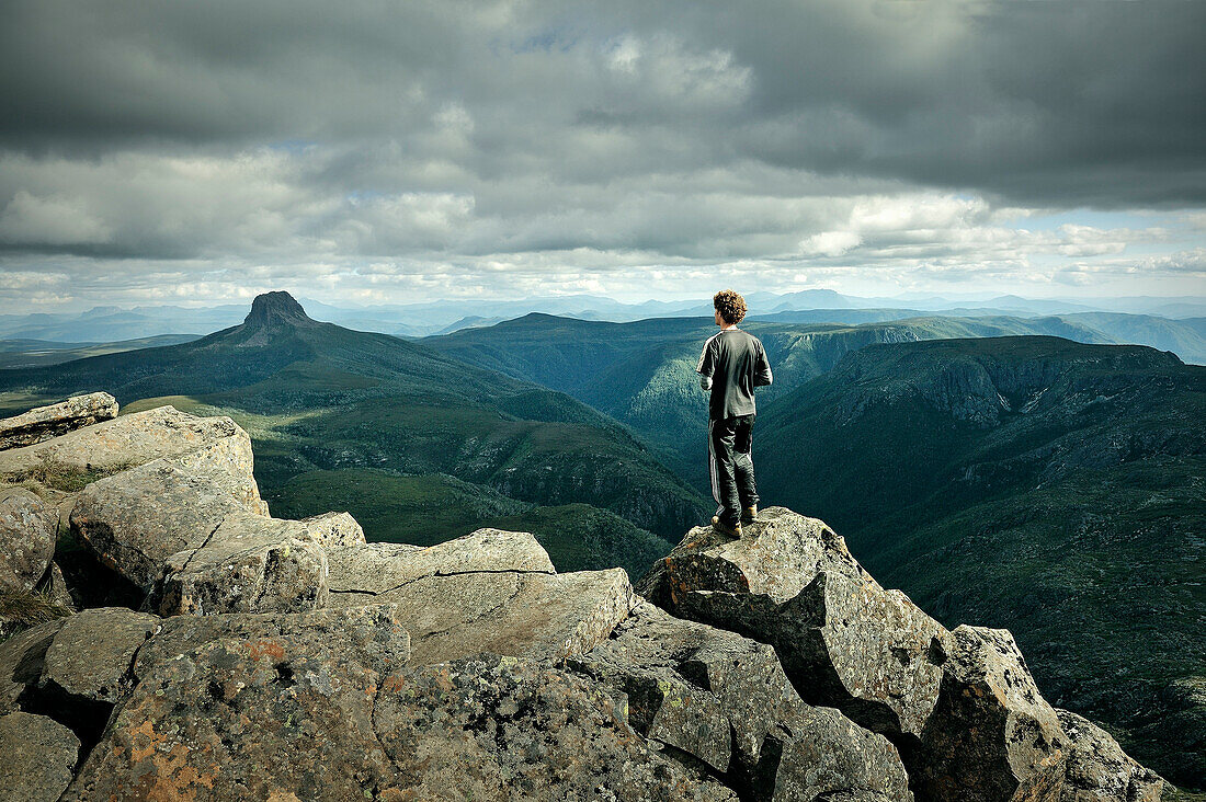 Hiker atop Cradle Mountain, view at Barn Bluff, Cradle Mountain Lake St Clair National Park, Tasmania, Australia