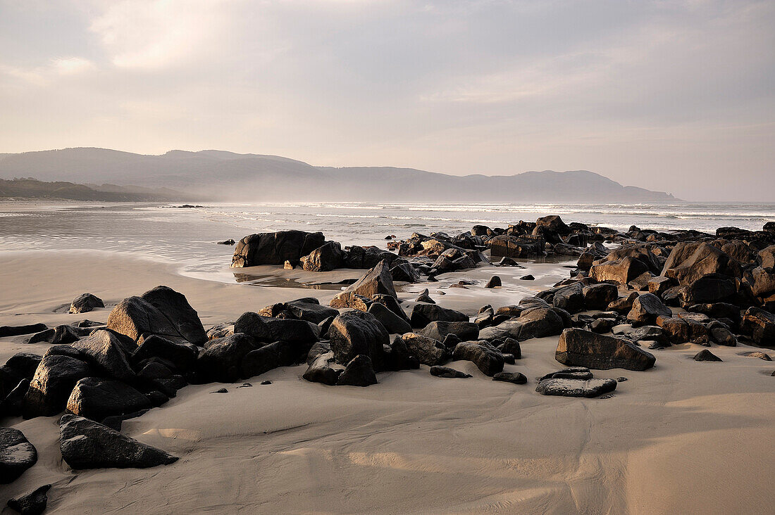 Beach with rocks and mountains, Cloudy Bay, Bruny Island, Tasmania, Australia