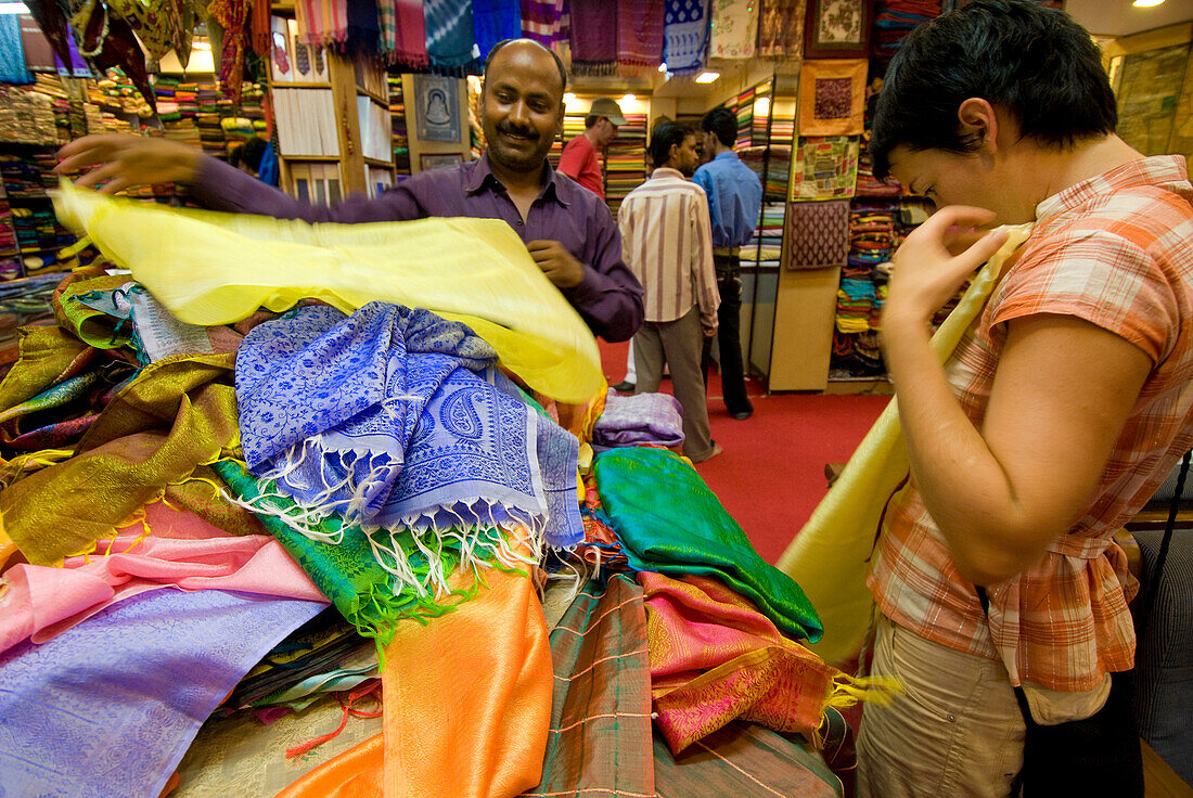 Woman being shown fabrics by salesman in a shop, Jaipur, Rajasthan, India