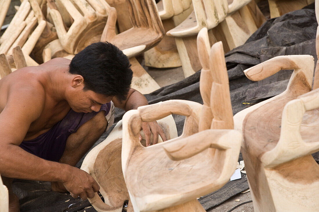 Man carving wooden hand chairs, Bali, Indonesia