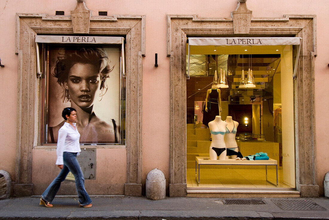 Woman walking past La Perla shop, Via Conotti, Rome, Italy