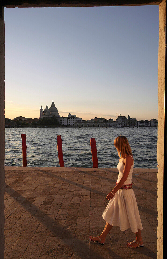 Woman walking along lagoon, Venice, Venice, Italy