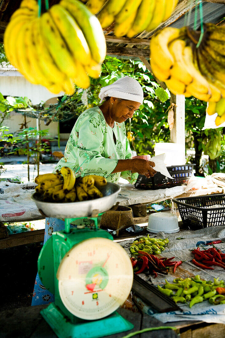 Fruit seller weighing out bananas, Terengganu, Malaysia