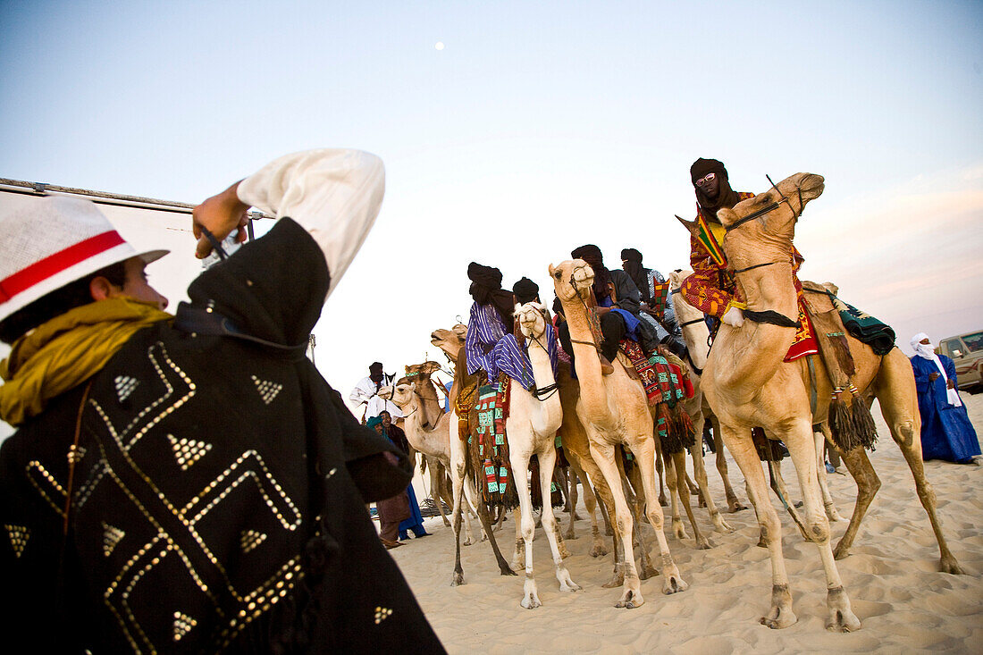 Tourist taking photos of Tuaregs on camels, Festival au Desert, Essakane, Mali