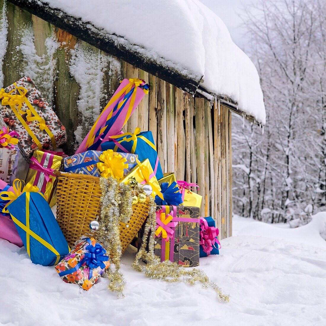 Christmas presents by log hut with snowy roof