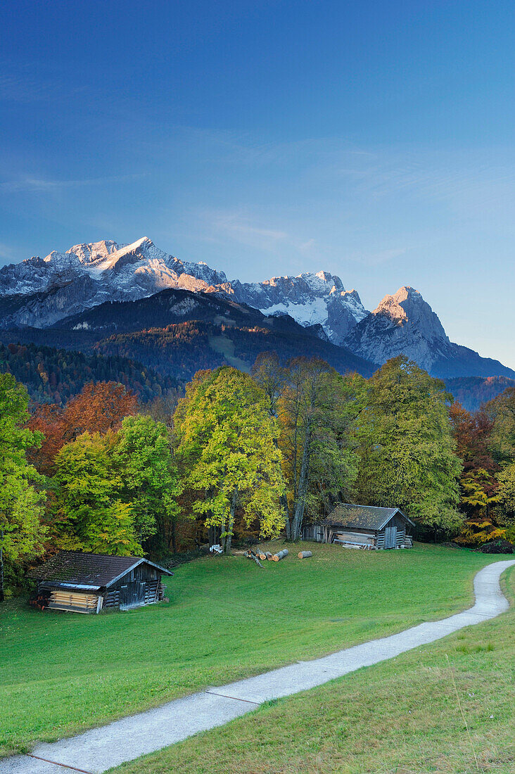 Wetterstein range with Alpspitze, Zugspitze and Waxensteine, meadow, farm shed and trees in autumn colours in foreground, Garmisch-Partenkirchen, Wetterstein range, Upper Bavaria, Bavaria, Germany, Europe