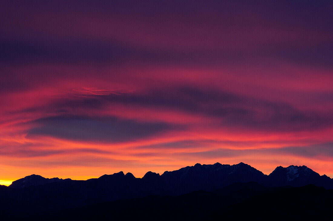 Clouds above silhouettes of Berchtesgaden range with Hoher Goell, Watzmann, Hochkalter and Hocheiser in the afterglow, Wendelstein range, Bavarian alps, Upper Bavaria, Bavaria, Germany, Europe