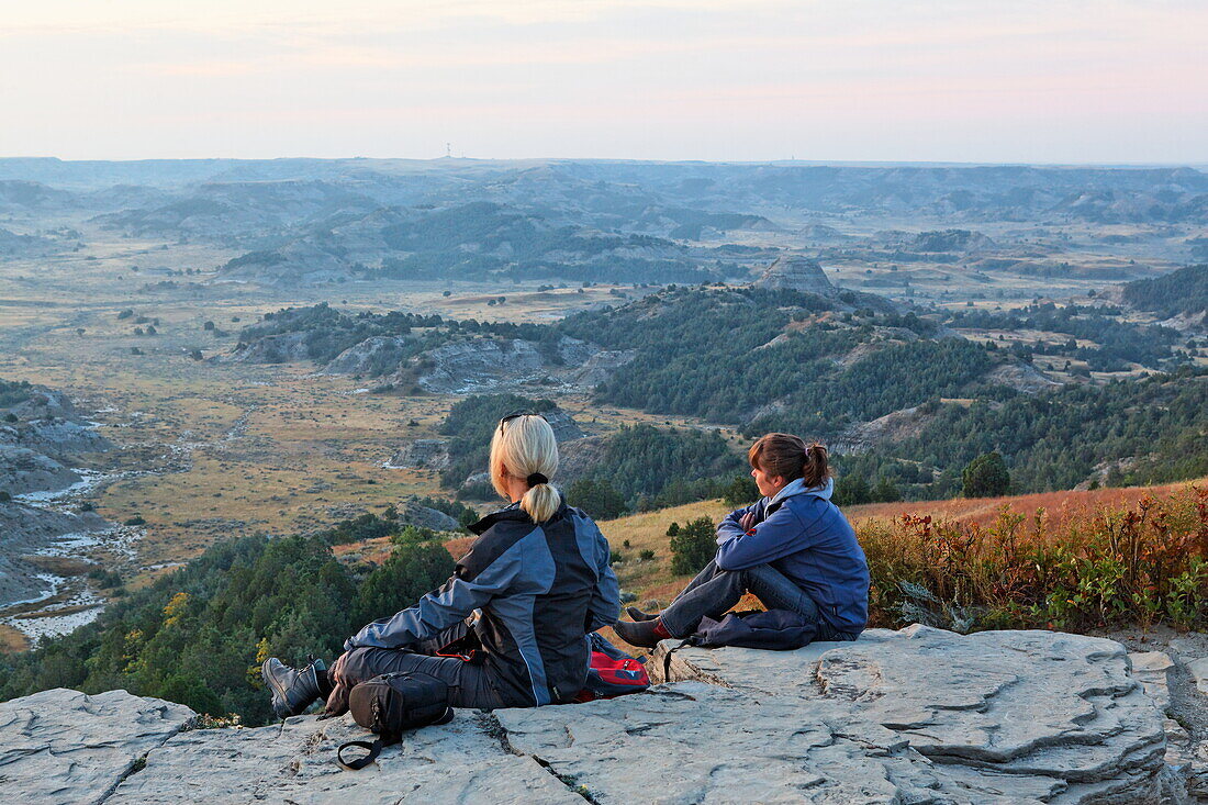 Zwei Frauen sitzen auf Felsen, Theodore Roosevelt National Park, Medora, North Dakota, USA