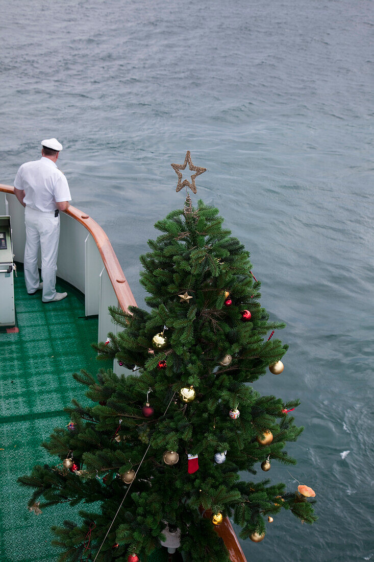 Ein Weihnachtsbaum auf der Nock der Brücke vom Kreuzfahrtschiff MS Deutschland, Reederei Peter Deilmann, samt Kapitän, nahe Cabo Frio, Rio de Janeiro, Brasilien, Südamerika