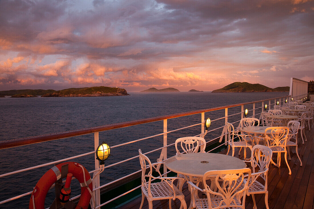 Tische und Stühle an Deck von Kreuzfahrtschiff MS Deutschland, Reederei Peter Deilmann, bei Sturm und Sonnenuntergang, Cabo Frio, Rio de Janeiro, Brasilien, Südamerika